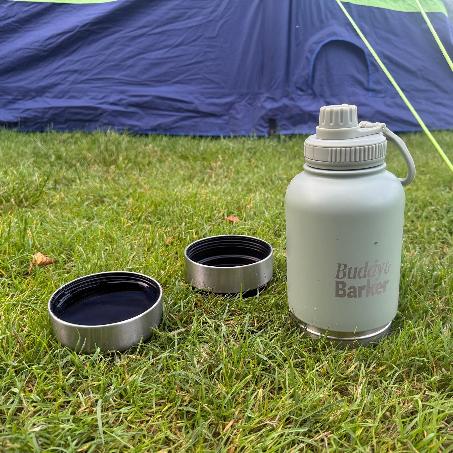 dog travel bottle with two bowls next to a tent