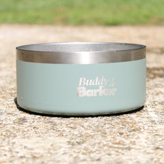 Dog bowl with 'Buddy & Barker' branding on a concrete surface.